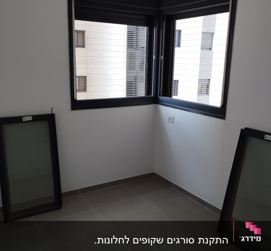 מסגרות אלומיניום שחורות עם זכוכית בחדר ריק